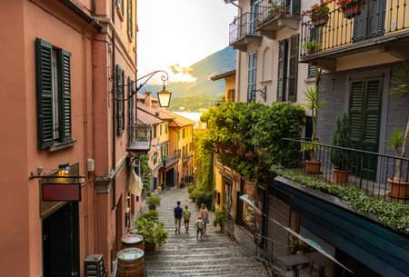 Family Walking Down Scenic European Old Town Street at Sunset with Lake Viewの写真素材
