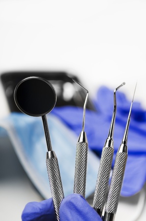 Gloved dentist hand holding dental instrumentsの写真素材
