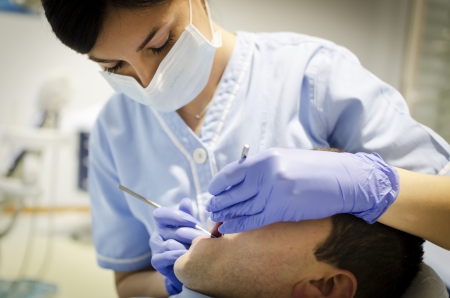 Woman dentist with patient, doing routine dentist office checkupの写真素材
