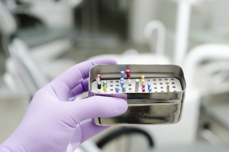 Gloved hand holding  endodontic boxes with probesの写真素材