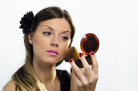 Pretty young girl putting makeup on.の写真素材