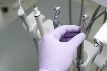 Hand of dentist holding dental drill machine with turbine

の写真素材