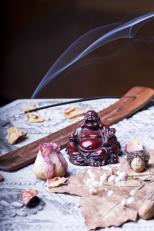 Buddah with scent stick on wooden tableの写真素材