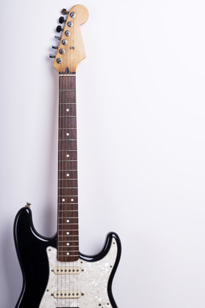 Black electric guitar on white backgroundの写真素材