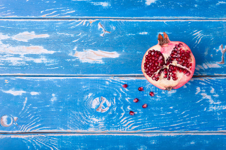 Juicy pomegranate fruit over wooden vintage tableの写真素材