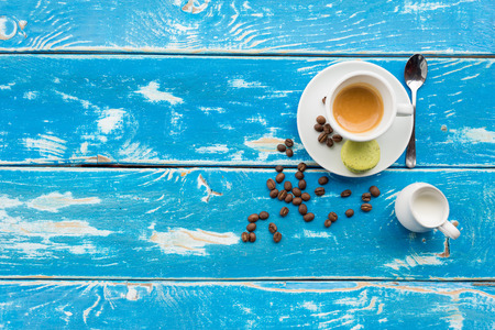 Cup of coffee on vintage table with coffee beans and milkの写真素材