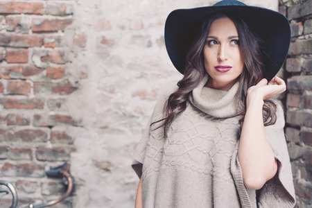 Young beautiful woman  against old stone wall, outdoor shot, retro vintage filtered lookの写真素材