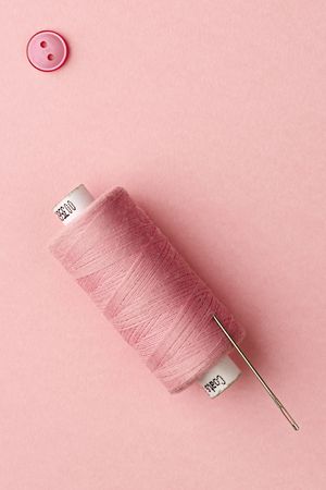 needle and pink thread with pink button on pinkの写真素材