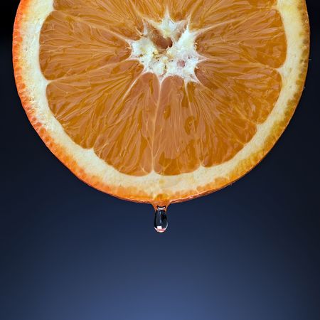 orange half with juice dropの写真素材