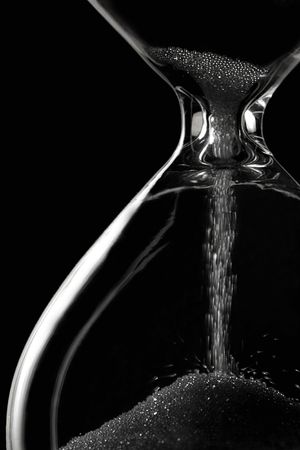 time is slipping away - hourglass on black
