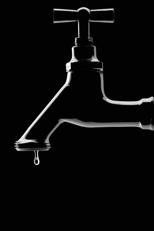 leaking tap - backlit on blackの写真素材