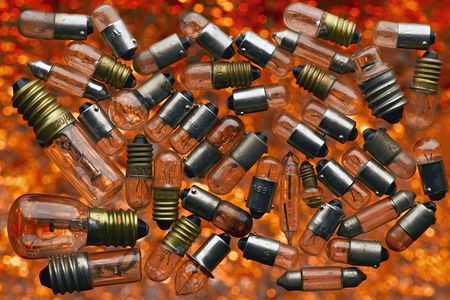 used light bulbs in a midair over orange backgroundの写真素材