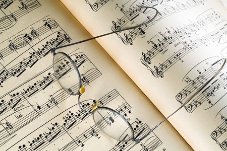 a pair of rimmed glasses on a music sheetの写真素材
