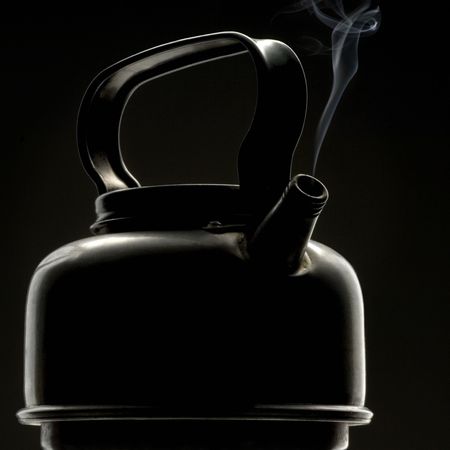 a fuming metal teapot against dark  - silhouetteの写真素材