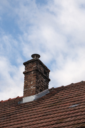 Brick chimney on the rooftop with cloudy weatherの写真素材