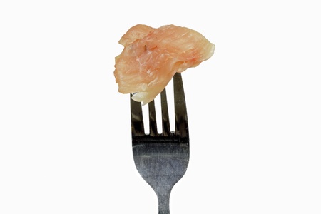 raw chicken on the fork on the white backgroundの写真素材