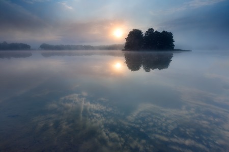 Beautiful sunrise over lake with reflections in waterの写真素材