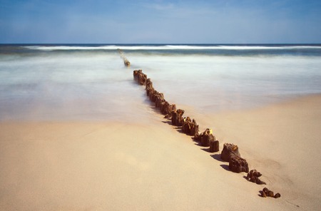Baltic sea coast with old wooden pier photographed on long exposure