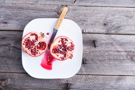 Healthy fresh pomegranates on old wooden tableの写真素材