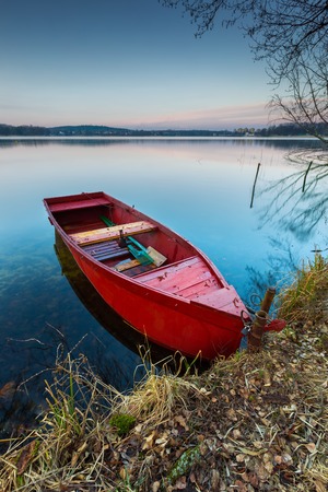 Beautiful lake landscape with boat on shore. Polish lake in Mazury lake district.の写真素材