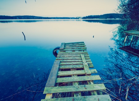 Lake landscape with jetty. Photo with vintage mood effect.の写真素材