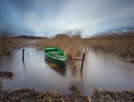 lake with boat. long exposure landscape. Autumnal bad weather landscape photographed on polish lake.の写真素材