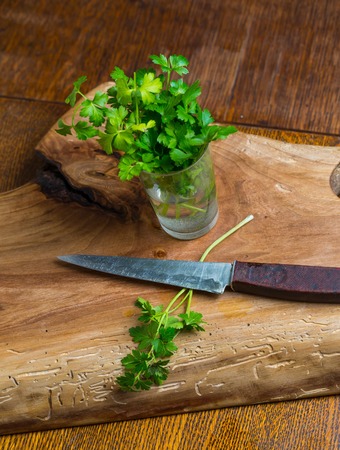 Green young parsley on old cutting board. Mystic light studio shotの写真素材