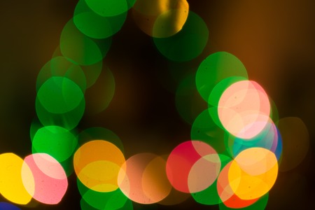 Christmas Bokeh background. Defocused colorful abstraction of lights on christmas treeの写真素材
