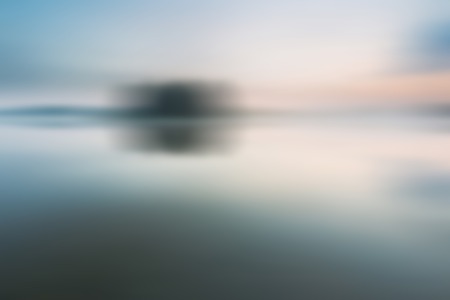 Out of focus, blurry lake landscape useful as background.の写真素材