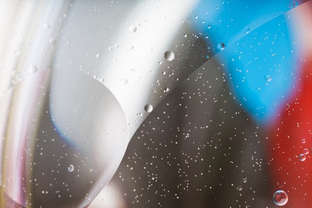 Abstraction of oil droplets on water surface. Macro of iluminated liquids.の写真素材