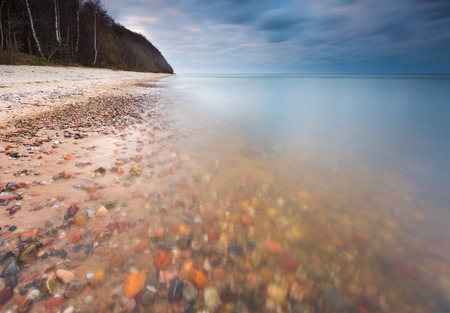 Beautifu rocky sea shore at sunrise or sunset. Long exposure landscape. Baltic sea near Gdynia in Poland.の写真素材