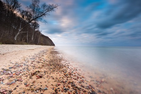 Beautifu rocky sea shore at sunrise or sunset. Long exposure landscape. Baltic sea near Gdynia in Poland.の写真素材