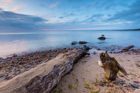 Beautiful rocky sea shore at sunrise or sunset. Long exposure landscape. Baltic sea near Gdynia in Poland.の写真素材