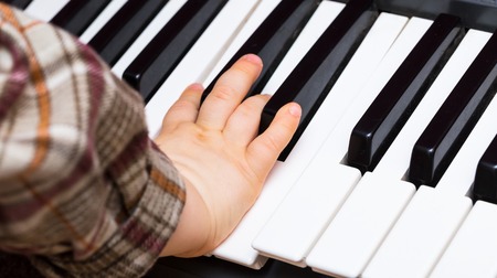 Close up of Keybord of synthetizer. Music abstract background with hands of children playing on...