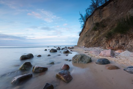 Beautiful Baltic sea shore with big cliff in Gdynia Orlowo. Seashore long exposure photo.の写真素材