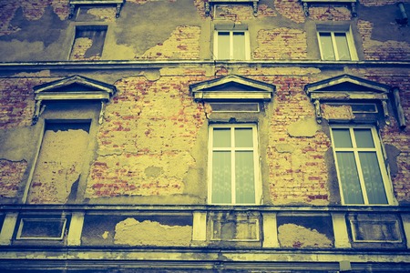 Vintage photo of old abandoned building with windows in old town.の写真素材
