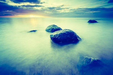 Vintage photo of beautiful long exposure landscape of rocky sea shore. Tranquil scene of Baltic sea near Gdynia in Poland.の写真素材
