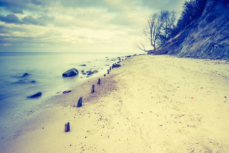 Vintage photo of beautiful long exposure landscape of rocky sea shore. Tranquil scene of Baltic sea near Gdynia in Poland.の写真素材