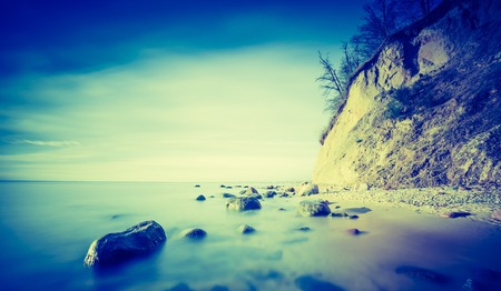 Vintage photo of beautiful Baltic sea shore with big cliff in Gdynia Orlowo. Seashore long exposure photo.の写真素材