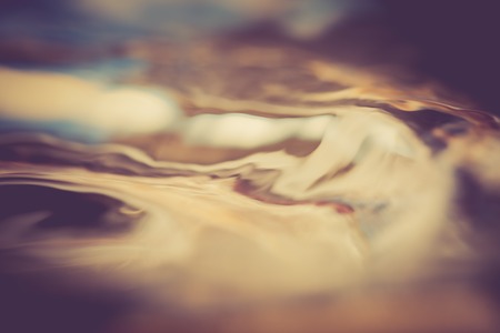 Abstract background of moving water surface in big close up. Photo with vintage colors.の写真素材