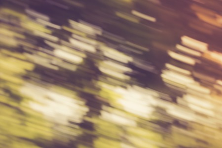 Vintage photo of blurry abstract background of green summer forest photographed on long exposure with motion effect.の写真素材