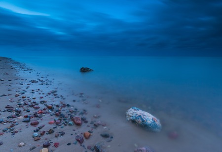 Beautiful long exposure landscape of rocky sea shore. Tranquil scene of Baltic sea.の写真素材