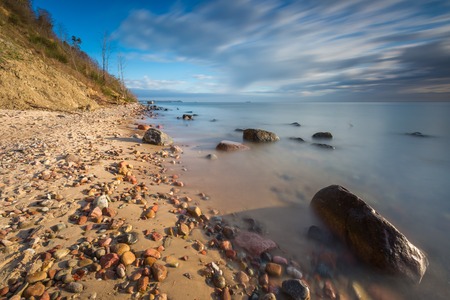 Beautiful long exposure landscape of rocky sea shore. Tranquil scene of Baltic sea.の写真素材