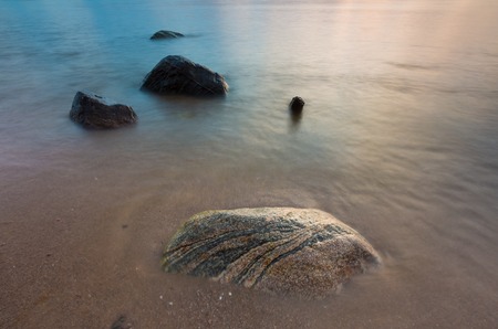Beautiful long exposure landscape of rocky sea shore. Tranquil scene of Baltic sea.