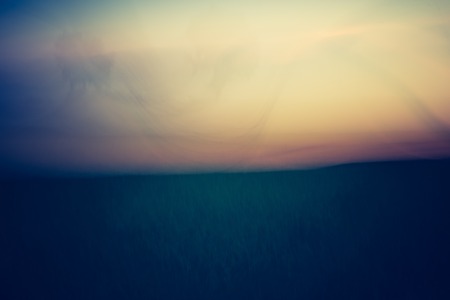 Abstract, blurry background of field after sunset. Photo with vintage moodの写真素材