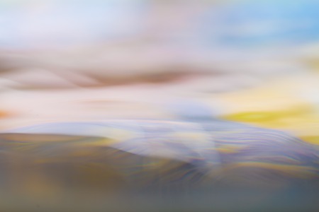 Moving water abstraction. Close up of water surface with colorful reflections