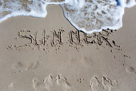 Inscription on beach sand. Sea shore close up with inscription. Summerの写真素材