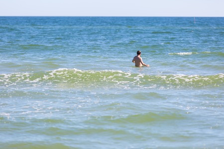 Man swimming in sea. Summertime photo of man standing in sea waterの写真素材
