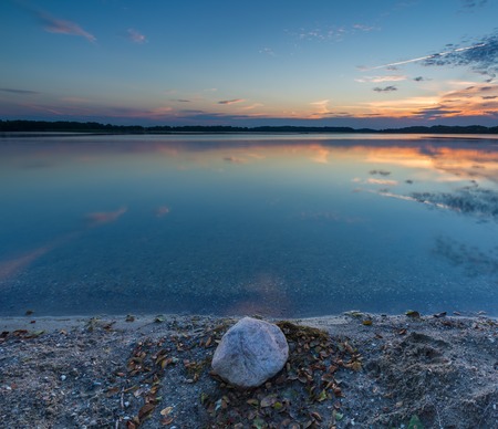 Beautiful lake at sunset landscape with cloudy sky reflecting in waterの写真素材