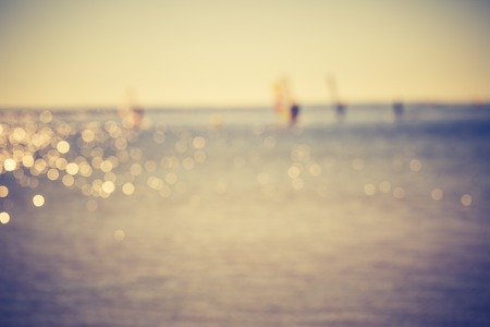 Vintage photo of defocused seascape with windsurfers on sea surface. Blurry landscape useful as backgroundの写真素材